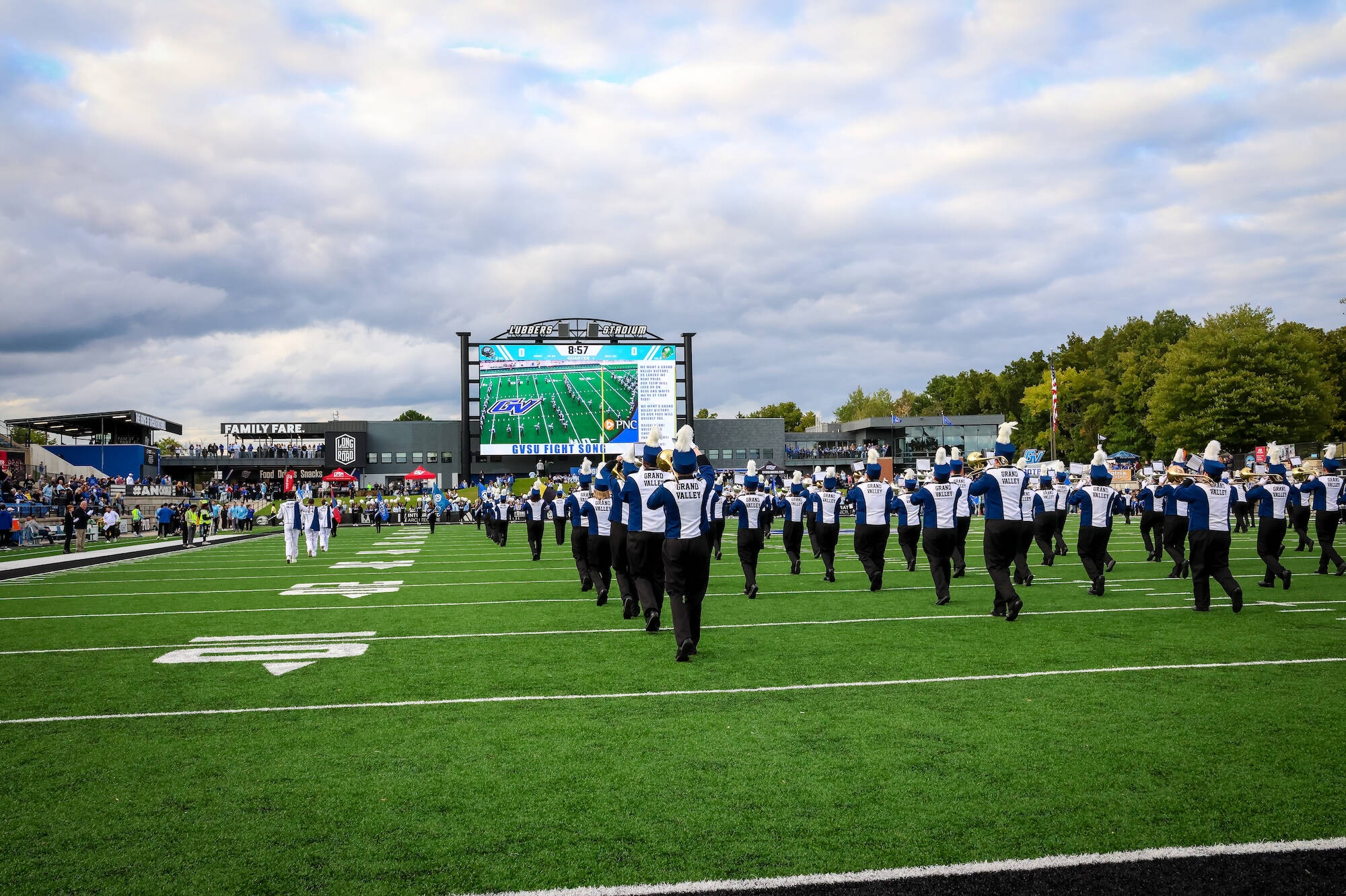 LMB marching pregame at lubbers stadium with the video board in the background